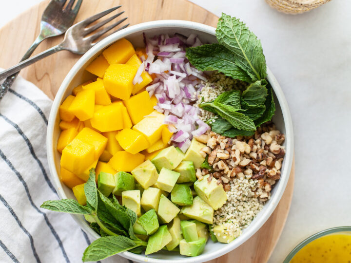 Overhead view of a bowl with Easy Mango Avocado Salad ingredients before mixing