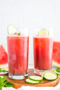 Two large glasses of watermelon juice with lime wedges