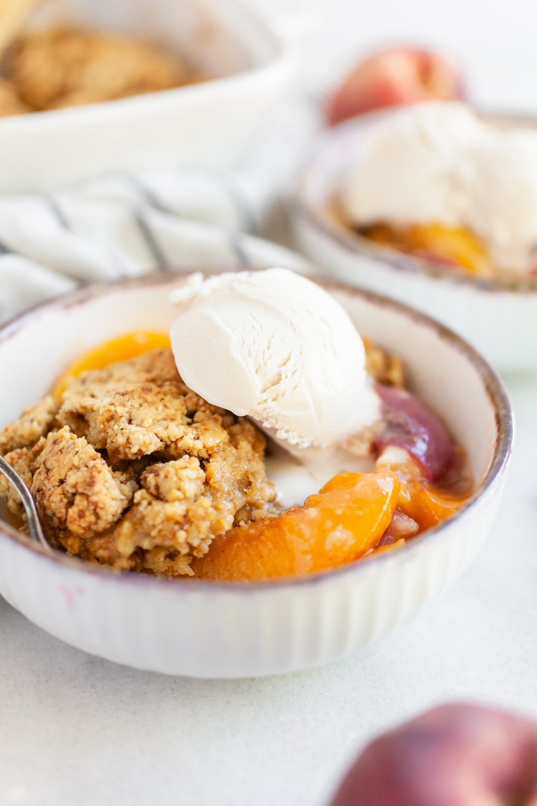 En skål med hälsosam peach cobbler med mjölkfri vaniljglass