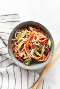 Peanut sauce noodle stir fry with vegetables in a bowl