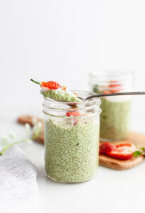 Spoon taking a scoop of Easy Matcha Chia Pudding out of a jar