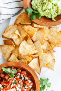 Platter of air fryer tortilla chips with guacamole and salsa