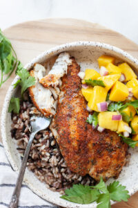 Plate of Air Fryer Tilapia on a bed of wild rice with mango salsa